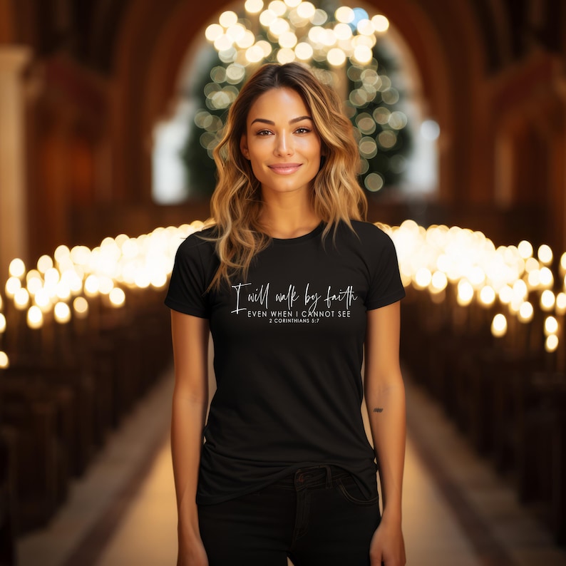 May include: A black t-shirt with the text "I will walk by faith, even when I cannot see, 2 Corinthians 5:7" in white script. The shirt is worn by a person in a church setting.
