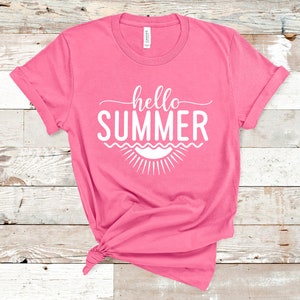 May include: Pink t-shirt with the text "hello summer" in white, with a stylized sun and waves underneath.
