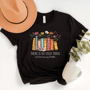 May include: Black t-shirt with a graphic of a stack of colorful books with flowers and the text "THERE IS NO SUCH THING as too many books".