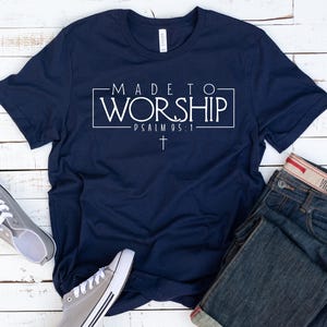 Puede incluir: Una camiseta azul marino con texto blanco que dice "MADE TO WORSHIP - PSALM 95:1" con un s&iacute;mbolo de cruz debajo del texto.