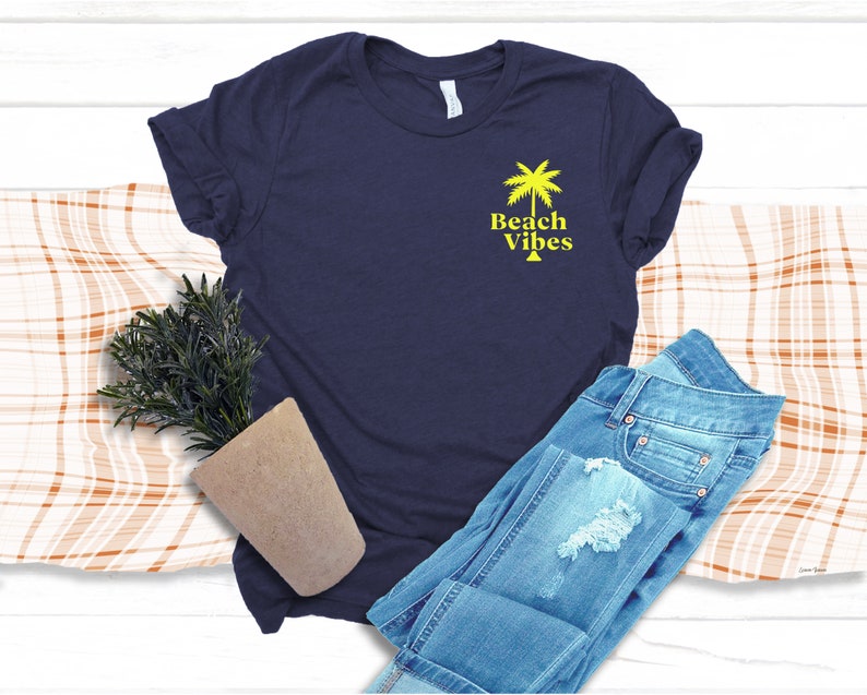May include: A navy blue t-shirt with a yellow palm tree and the text "Beach Vibes" on the front.
