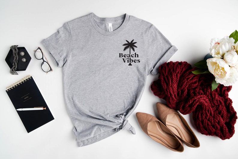 May include: A gray t-shirt with a palm tree graphic and the text "Beach Vibes" printed on the front.