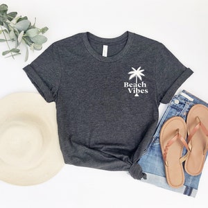 May include: A dark gray t-shirt with a white palm tree and the text "Beach Vibes" printed on the front.