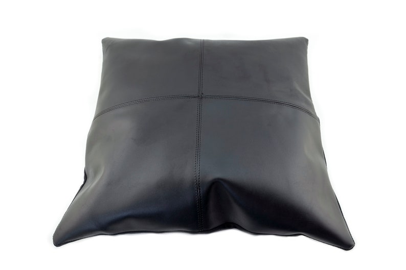 Pu&ograve; includere: Un cuscino in pelle nera con un design quadrato. Il cuscino &egrave; realizzato in pelle morbida e flessibile e ha una texture liscia e uniforme.