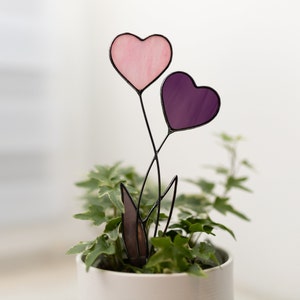 Stained glass suncatcher in a plant vase with 2 hearts instead of a pink and purple color