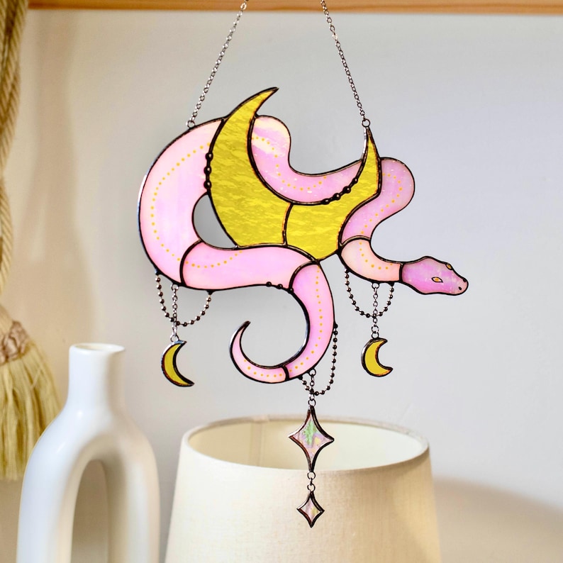 A pink and yellow stained glass snake wall hanging