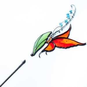 stained glass plant stake the orange butterfly that sits on the lily of the valley flower