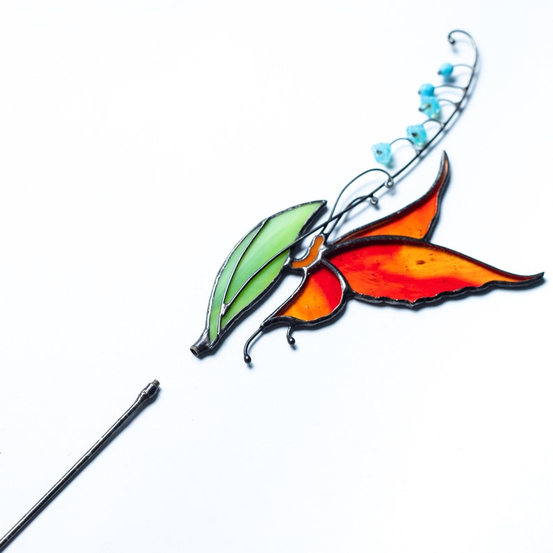 stained glass plant stake the orange butterfly that sits on the lily of the valley flower