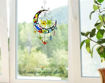 May include: A stained glass moon with stars hanging in a window. The moon is multi-colored with yellow, blue, red, and green. The text "VENUS GLASS A unique moon decor" is at the bottom of the image.