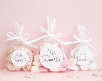 May include: Three clear cellophane bags filled with candy, tied with white ribbon. The bags are labeled with white circles that say "Her Favourite", "Our Favourite", and "His Favourite".