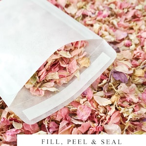 May include: White paper bags with a self-seal adhesive strip. The bags are filled with pink and white flower petals. The text "FILL, PEEL & SEAL" is printed on the bottom of the image.