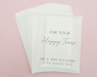 May include: A stack of white tissue paper envelopes with the text "For Your Happy Tears" and "Mr & Mrs Williams 27th August 2023" printed on the front.