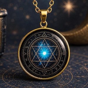 Op de afbeelding: Een goudkleurige hanger aan een ketting met een cirkelvormig frame en een zwart-blauw kosmisch ontwerp. Het midden toont een gouden zespuntige ster met een helder licht in de kern, omringd door een ring van complexe, abstracte symbolen.