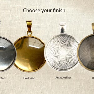May include: Four circular pendant trays with bails, labeled Choose your finish. The options are stainless steel, gold tone, antique silver, and bronze. Each pendant features a smooth, rounded surface, with the antique silver and bronze showing a textured pattern.