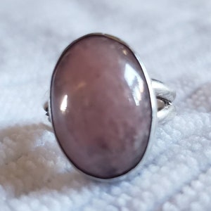 Puede incluir: Un anillo de plata con una gran piedra preciosa ovalada de color rosa.