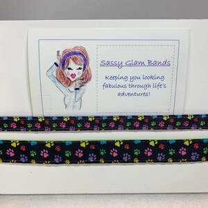Multi-colored paw prints on black grosgrain available in either 5/8&quot; or 1&quot; width headband