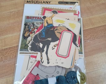 May include: A Sasparilla Miscellany October Afternoon package containing assorted paper ephemera, die-cut cards, and shapes. The collection features a cowboy riding a bucking horse, a red-bordered label, a horseshoe, buttons, and teal ribbon.