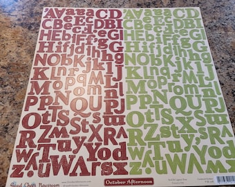 May include: A sheet of alphabet stickers with red and green letters on a white background. The letters are in a variety of fonts and sizes. The sheet is labeled "October Afternoon" and "Good Cheer Newsroom".