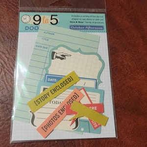 May include: A package of die-cut paper shapes with a vintage theme. The shapes include labels and note card designs in shades of blue, yellow, and peach. Text includes "9 to 5", "October Afternoon", "Story Enclosed", and "Photos Enclosed".