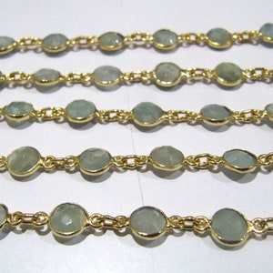 Puede incluir: Una cadena de oro con cuentas de piedras preciosas de color azul claro. La cadena est&aacute; hecha de peque&ntilde;as piezas de metal unidas. Las piedras preciosas son redondas y tienen un acabado liso y pulido.