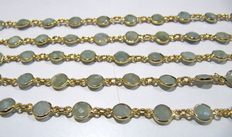 Puede incluir: Una cadena de oro con cuentas de piedras preciosas de color azul claro. La cadena est&aacute; hecha de peque&ntilde;as piezas de metal unidas. Las piedras preciosas son redondas y tienen un acabado liso y pulido.