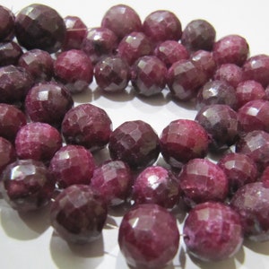 Op de afbeelding: Een streng diep rode gefacetteerde edelsteen kralen. De kralen zijn rond en hebben een gepolijste afwerking.