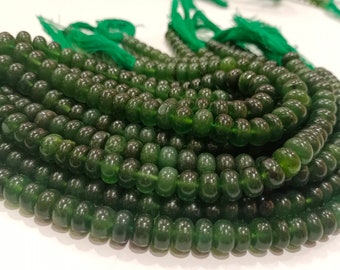 Pode incluir: Um fio de contas de jade verde escuro, cada conta é redonda e lisa. As contas são enfiadas em um cordão fino e estão prontas para serem usadas para fazer joias.