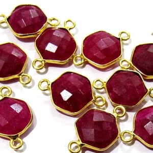 May include: Ten gold-toned gemstone connectors with faceted ruby red stones. Each connector has two jump rings for attaching to jewelry.