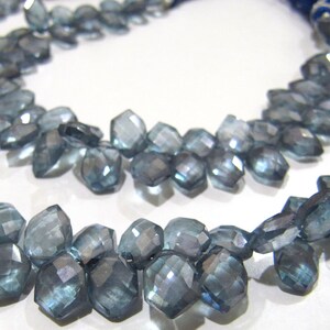 May include: A strand of faceted blue topaz gemstone beads. The beads are faceted and have a light blue color. The beads are strung on a string and are ready to be used for jewelry making.