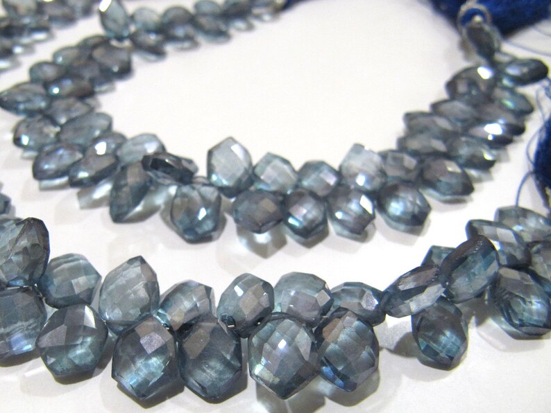 May include: A strand of faceted blue topaz gemstone beads. The beads are faceted and have a light blue color. The beads are strung on a string and are ready to be used for jewelry making.