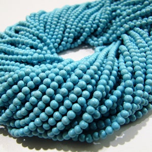 May include: A strand of turquoise blue round beads. The beads are smooth and uniform in size and color.
