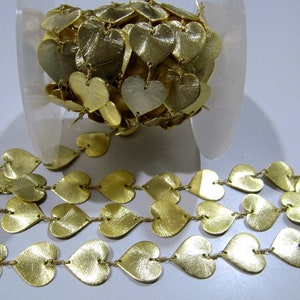 May include: A gold heart-shaped chain trim with a metallic finish. The chain is made of individual heart-shaped links connected by small metal rings.
