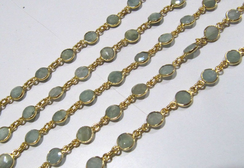 Puede incluir: Una cadena de oro con cuentas de piedras preciosas de color azul claro. La cadena est&aacute; hecha de peque&ntilde;as piezas de metal unidas y presenta piedras preciosas redondas y facetadas.