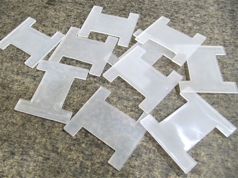 May include: A pile of ten clear plastic bobbins for thread.
