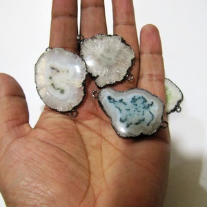 May include: Four agate slices with silver-toned metal connectors. The agate slices are white with green and blue inclusions.