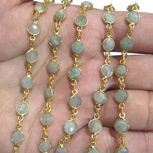 Puede incluir: Una cadena de oro con cuentas redondas de piedra preciosa gris claro. La cadena est&aacute; hecha de metal chapado en oro y las cuentas tienen un di&aacute;metro aproximado de 6 mm.