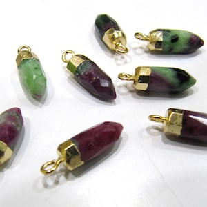 Peut inclure: Huit pendentifs en pierre précieuse plaqués or avec une pointe pointue. Les pierres précieuses sont un mélange de vert et de rose.