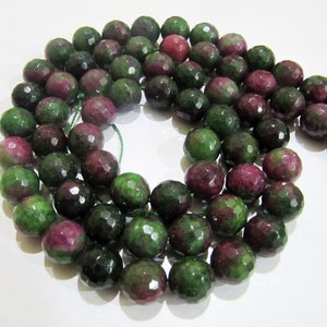 May include: A strand of faceted green and pink gemstone beads. The beads are round and have a polished finish.