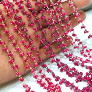 Könnte beinhalten: Nahaufnahme von Strängen aus rosa Edelsteinperlen auf Gold- und Silberketten. Die Perlen sind klein und geclustert, wodurch ein zartes Aussehen entsteht. Die Ketten werden in einer Hand gehalten, um die Details zu zeigen.