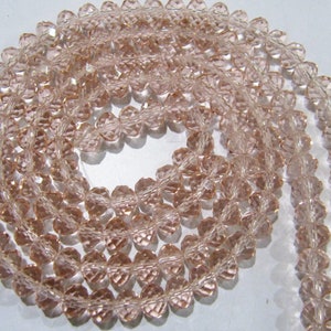 May include: A strand of light pink faceted glass beads. The beads are heart-shaped and have a clear, translucent appearance.