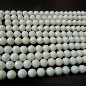 May include: A strand of white round beads, made of natural shell, for jewelry making.
