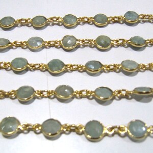 Puede incluir: Una cadena de oro con cuentas de piedras preciosas de color azul claro. La cadena est&aacute; hecha de peque&ntilde;as piezas de metal unidas. Las cuentas son redondas y tienen una apariencia ligeramente facetada.