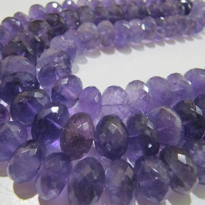 May include: A strand of purple amethyst beads, each bead is faceted and has a rounded shape.