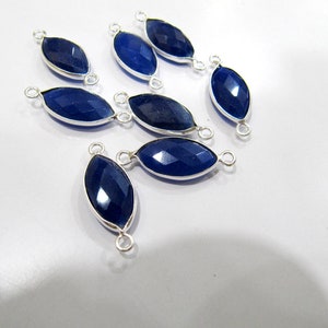 Pode incluir: Dez pingentes de conector de pedra preciosa azul com configurações de metal prateado. Cada pingente tem dois laços para anexar a joias.