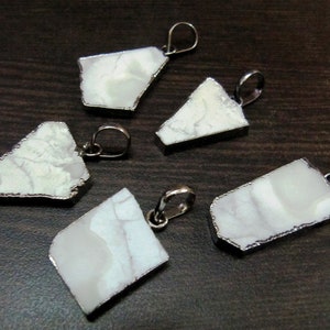 May include: Five white agate pendants with silver-toned metal settings. Each pendant has a unique shape and is ready to be strung on a necklace or bracelet.