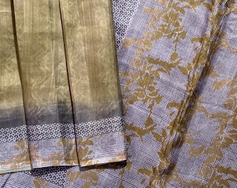 Könnte beinhalten: Ein braunes und goldenes Sari mit einem Blumenmuster. Das Sari hat einen Rand mit einem karierten Muster.
