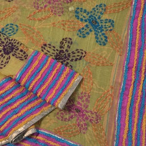 May include: A sheer olive green fabric featuring embroidered floral patterns in purple, blue, and orange. The border displays horizontal stripes in bright pink, blue, and yellow, accented with a thin metallic silver trim along the edge.