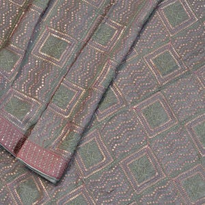 May include: A grey fabric featuring a repeating geometric pattern of squares outlined in pink sequins. Within each square is a textured grey motif, and between the squares are wavy lines of pink sequins, creating a structured, shimmering textile.