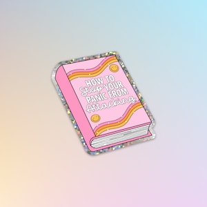 Könnte beinhalten: Rosaer Buch-Aufkleber mit Glitzer und einem Regenbogen-Design. Der Buchumschlag lautet "Wie man seine Panikattacken stoppt".