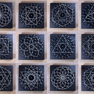 May include: Twelve black square wooden boards with white string art designs. Each board features a different geometric pattern, including circles, squares, triangles, and stars.